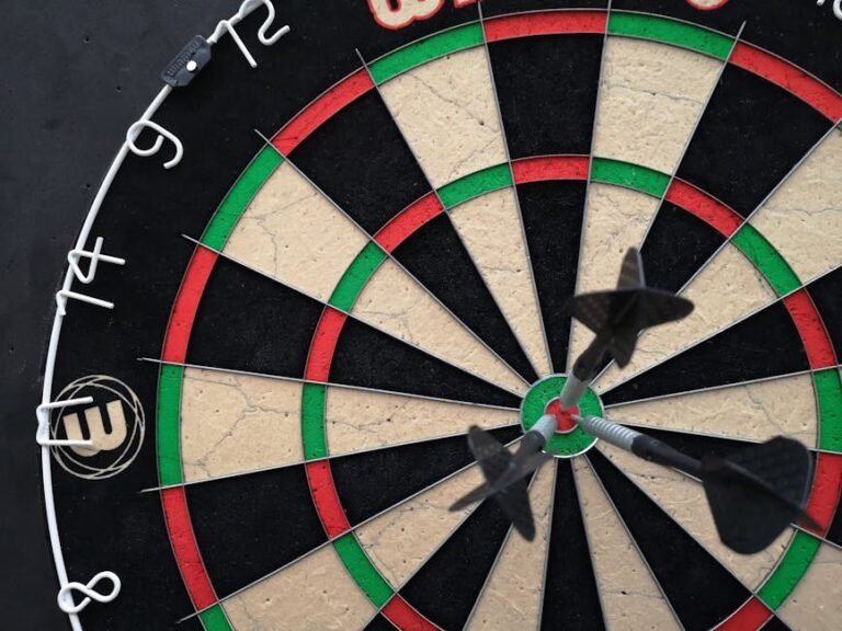 Precision-focused close-up view of darts hitting the bullseye on a dartboard.