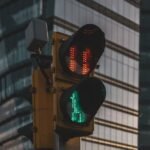 Traffic light at intersection with skyscraper backdrop in Mexico City.