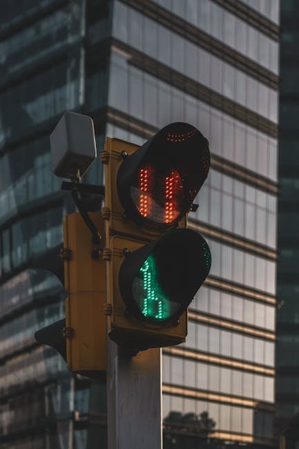 Traffic light at intersection with skyscraper backdrop in Mexico City.
